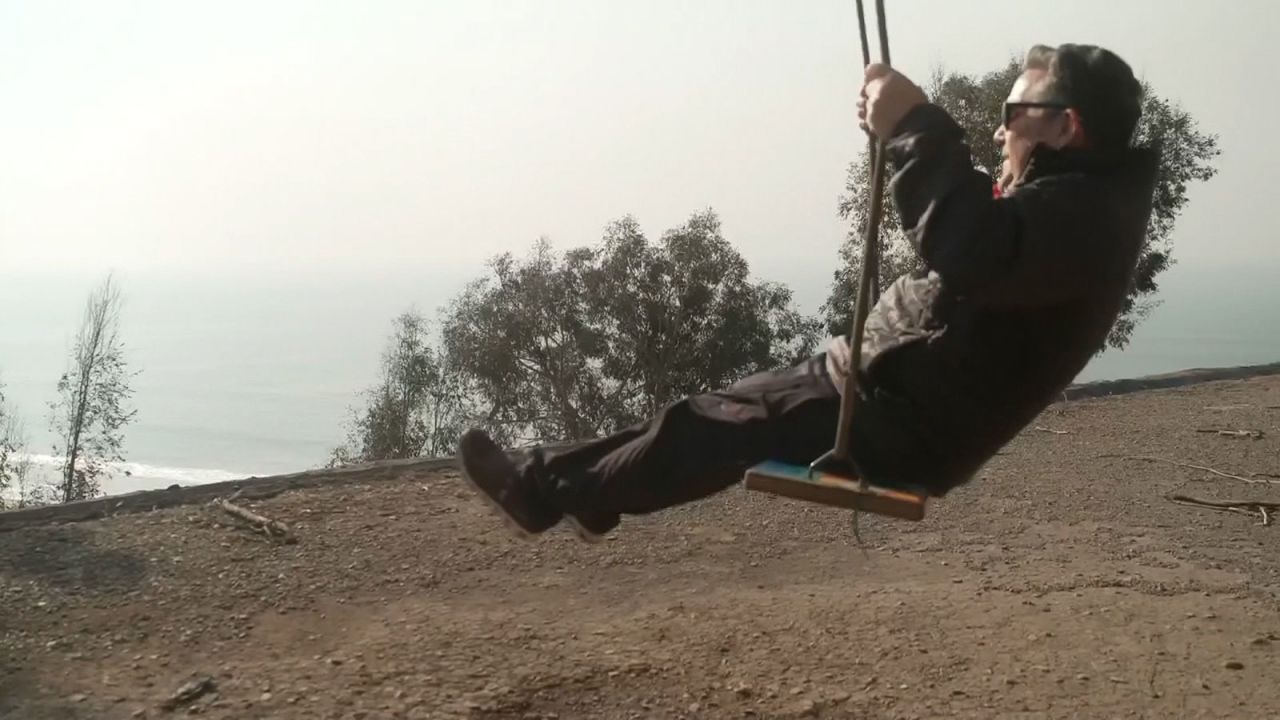 Marco Assante takes a moment to relfect on a swing after finding his home destroyed by the in the Palisades neighborhood.