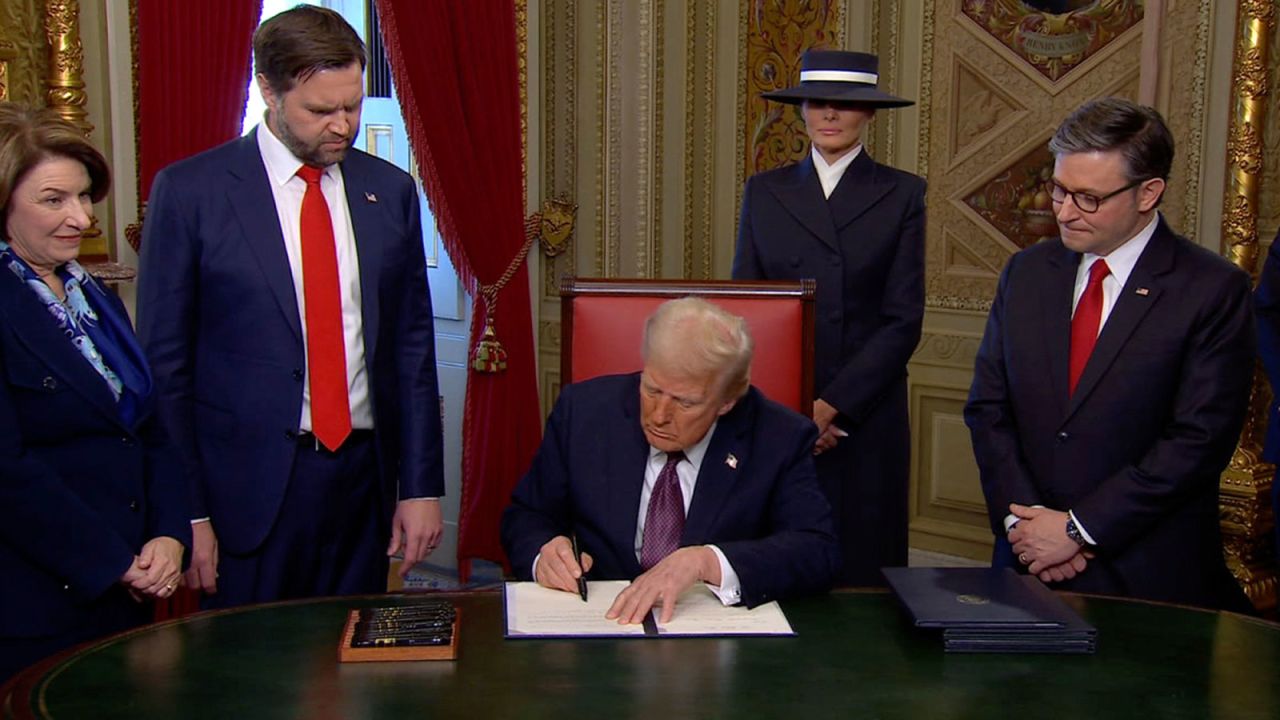 President Donald Trump signs documents on Monday.