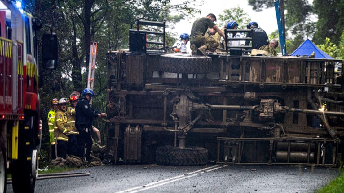 Personas en la escena de un accidente de camión militar en Lismore, Nueva Gales del Sur, el sábado 8 de marzo. 
