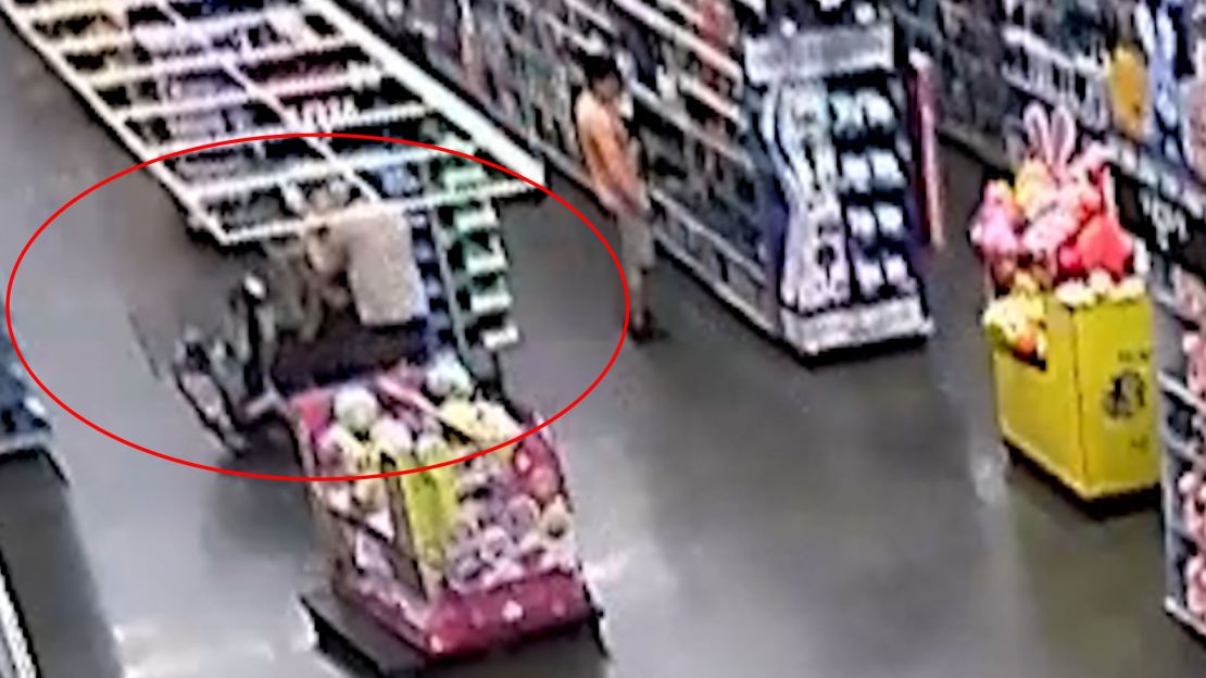 This still image from surveillance video shows Mahendra Patel reaching toward motorized scooter occupied by Caroline Miller and two children during their first encounter in the store. CNN has highlighted a portion of this image.