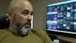 “Kir," a member of the National Guard of Ukraine, sits by a monitor showing a number of camera feeds.