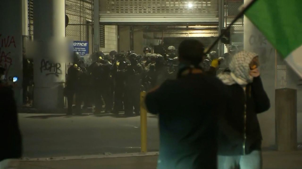 In this screengrab of a video, police emerge from the Federal Building in downtown Los Angeles on Sunday. A portion of the frame has been blurred.