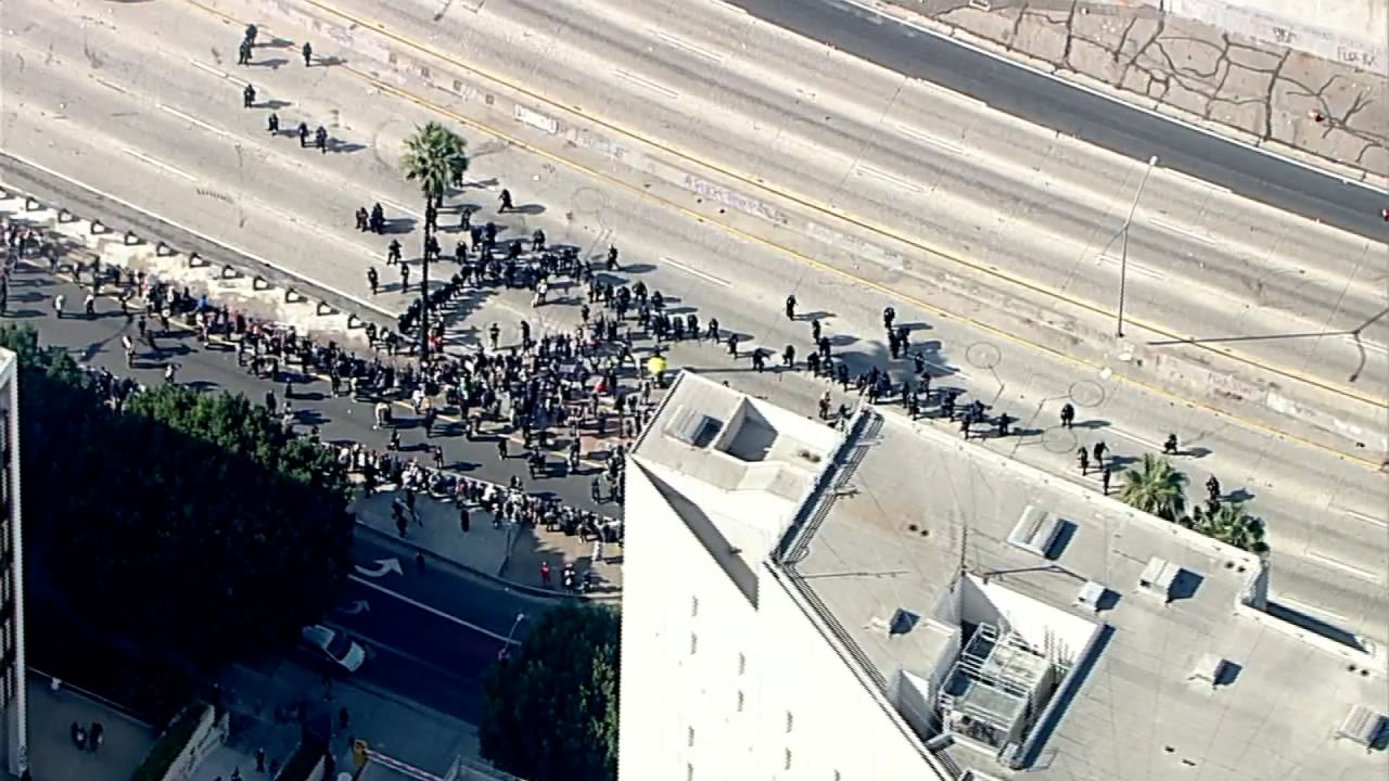 Police use an "L-formation" to clear the 101 Freeway of protesters in Los Angeles on Sunday.