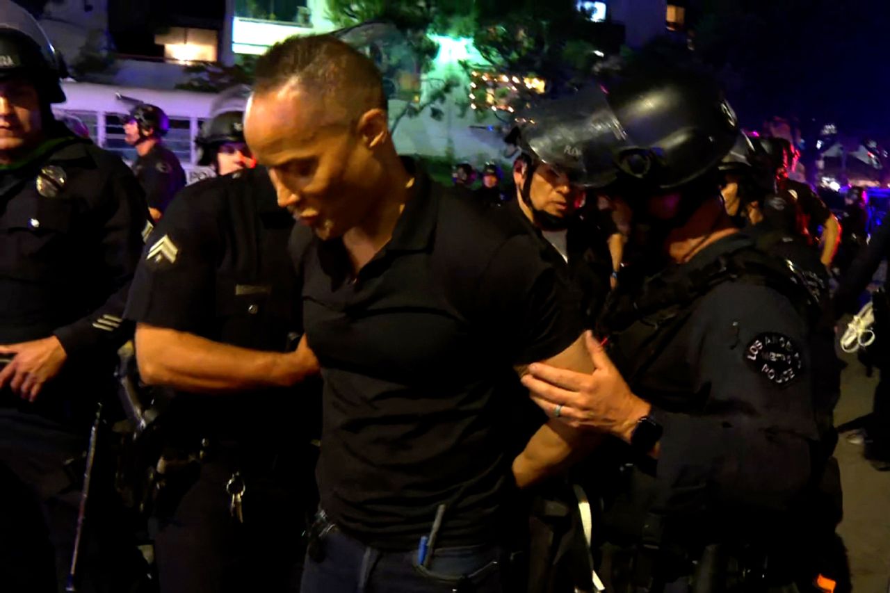 This screengrab shows police officers asking CNN reporter Jason Carroll to place his hands behind his back as he and his crew are escorted out of a protest zone in downtown Los Angeles on Monday.