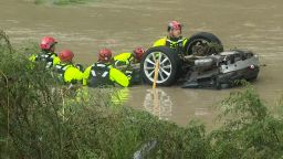 Rescue crews search a vehicle trapped in floodwaters in San Antonio, Texas, on Thursday morning.