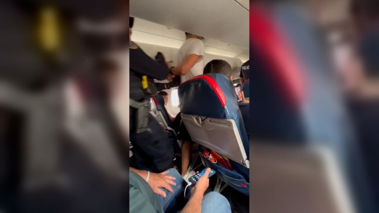 A passenger is escorted off Delta Connection flight 3612 after making an emergency landing in Cedar Rapids, Iowa on Thursday.