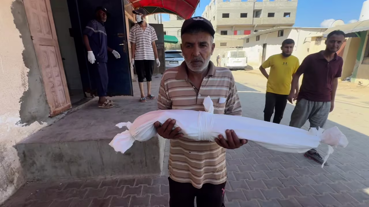 Razan Abu Zaher’s shrouded body is carried after she died from malnutrition.