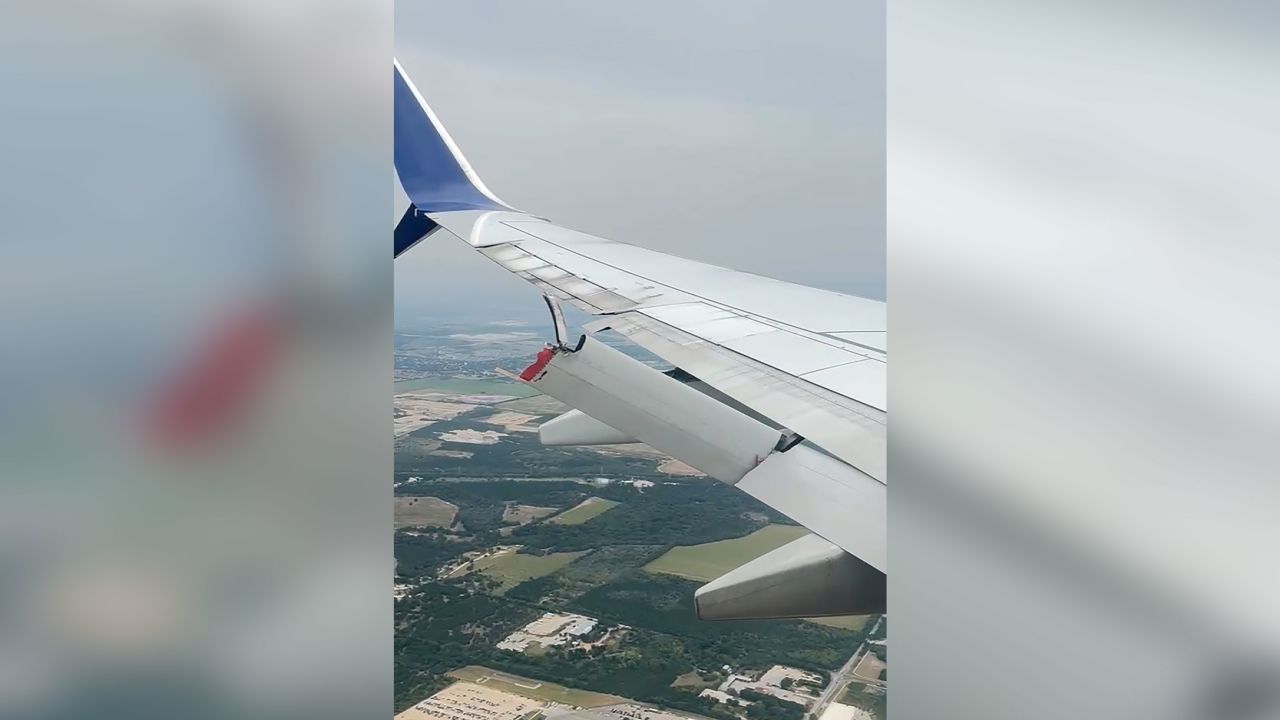  A still from a video taken aboard a Delta flight Tuesday, August 19, 2025, shows a flap dangling behind a wing of the plane.