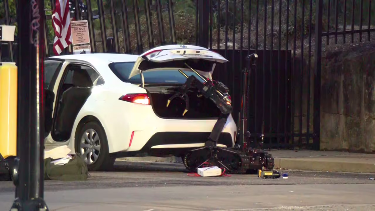 A robot is used to search the trunk of a car that rammed into a gate at the Pittsburgh FBI field office on Wednesday.