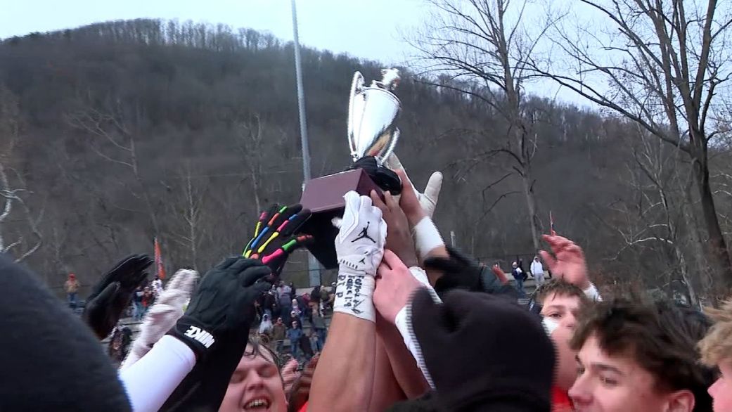 Union High School football players lift a trophy after winning a game Saturday, November 29, pushing them into the state semifinals.