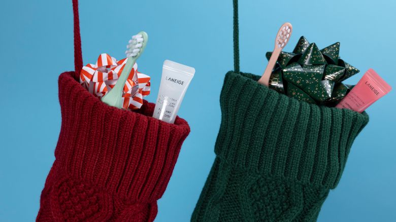 a red stocking and a green stocking each holding an electric toothbrush and Laneige shimmery lip balm