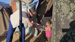 Jiab Suleiman distributes food to children living in a refugee camp in Khan Younis, in April.