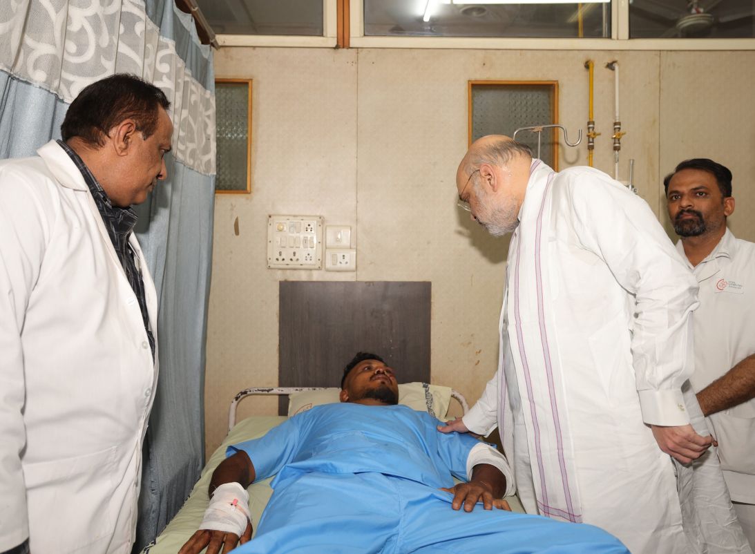 Air India crash survivor Vishwash Kumar Ramesh greets India Minister of Home Affairs Amit Shah at a hospital in June 2025.