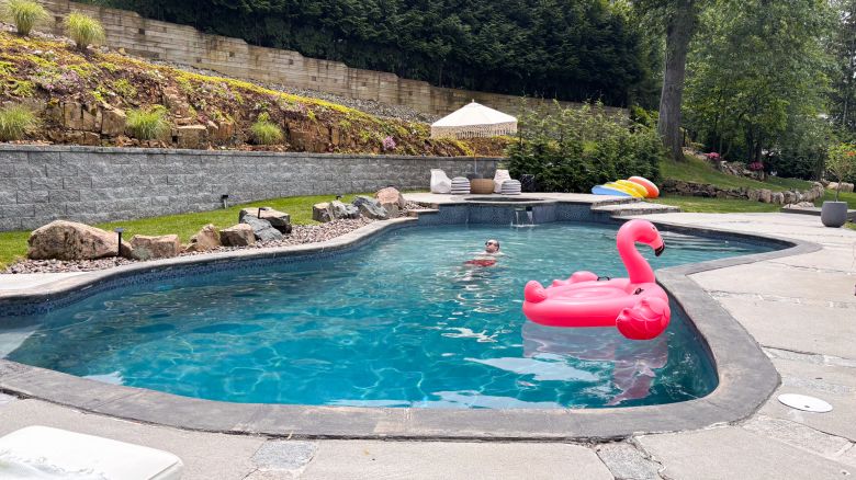 A person and an inflatable flamingo in a pool.
