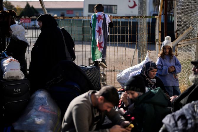 Syrians wait to cross into Syria from Turkey at the Oncupinar border gate in southern Turkey on December 9.