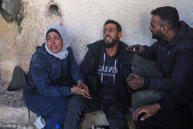 People react as they wait for news of loved ones while Syrian rescuers search the Sadnaya military prison in Damascus on December 9.