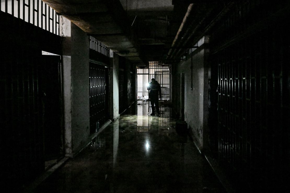 A man walks along a wet corridor past cells at the security detention center called Palestine Branch in Damascus on December 13.