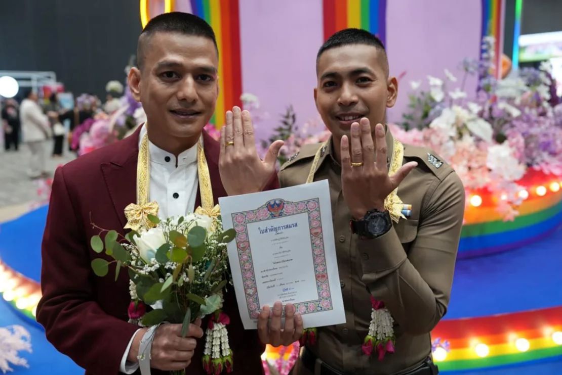 El sargento mayor de policía Pisit Sirihiranchai, a la derecha, muestra su anillo con su esposo Chanathip Sirihiranchai.