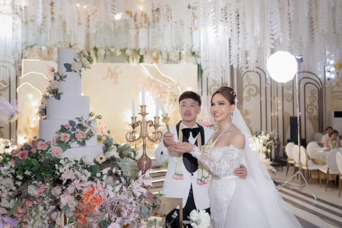 Nina Chetniphat Chuadkhunthod, derecha, y su marido encienden una vela durante su boda en el Vivace Wedding Hall de Bangkok.