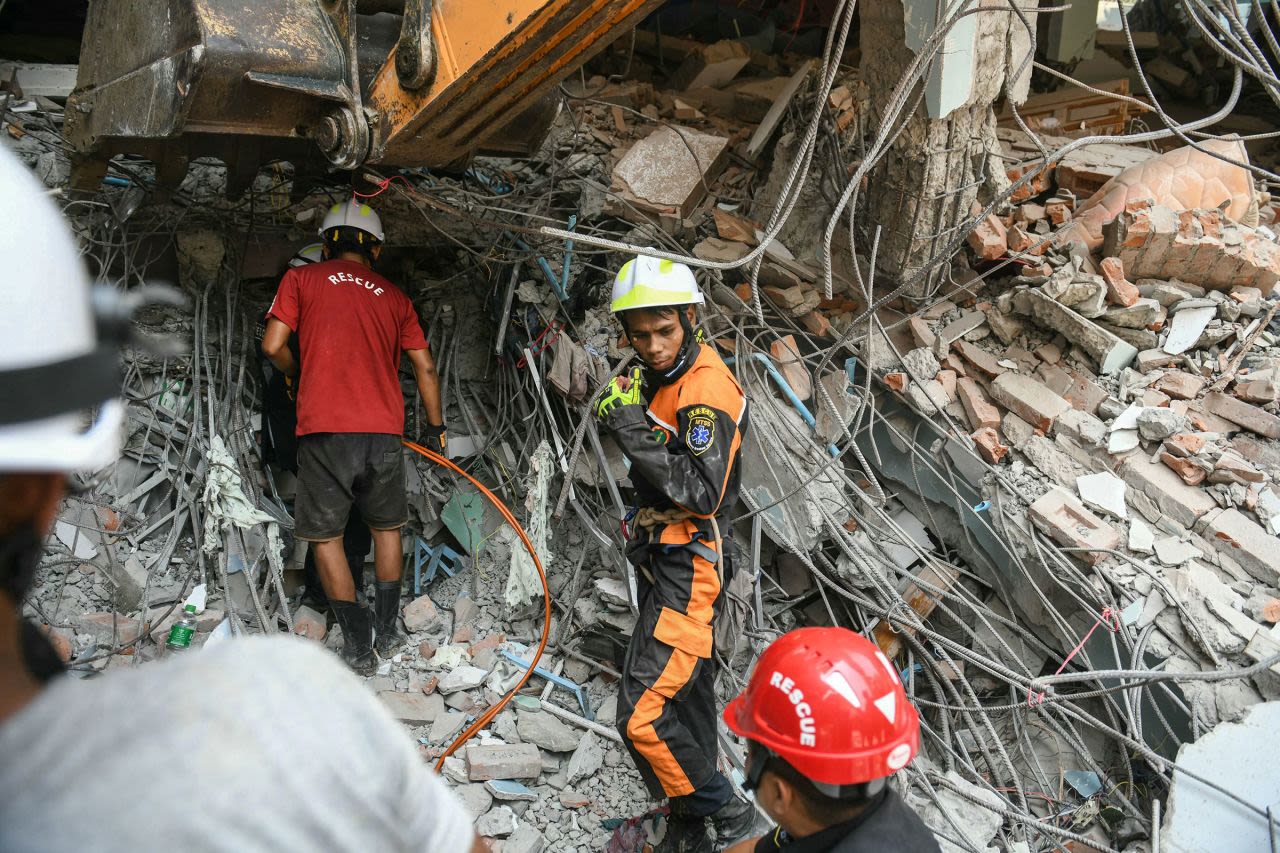 Rescatistas buscan sobrevivientes entre los escombros de un edificio dañado en Mandalay el sábado.