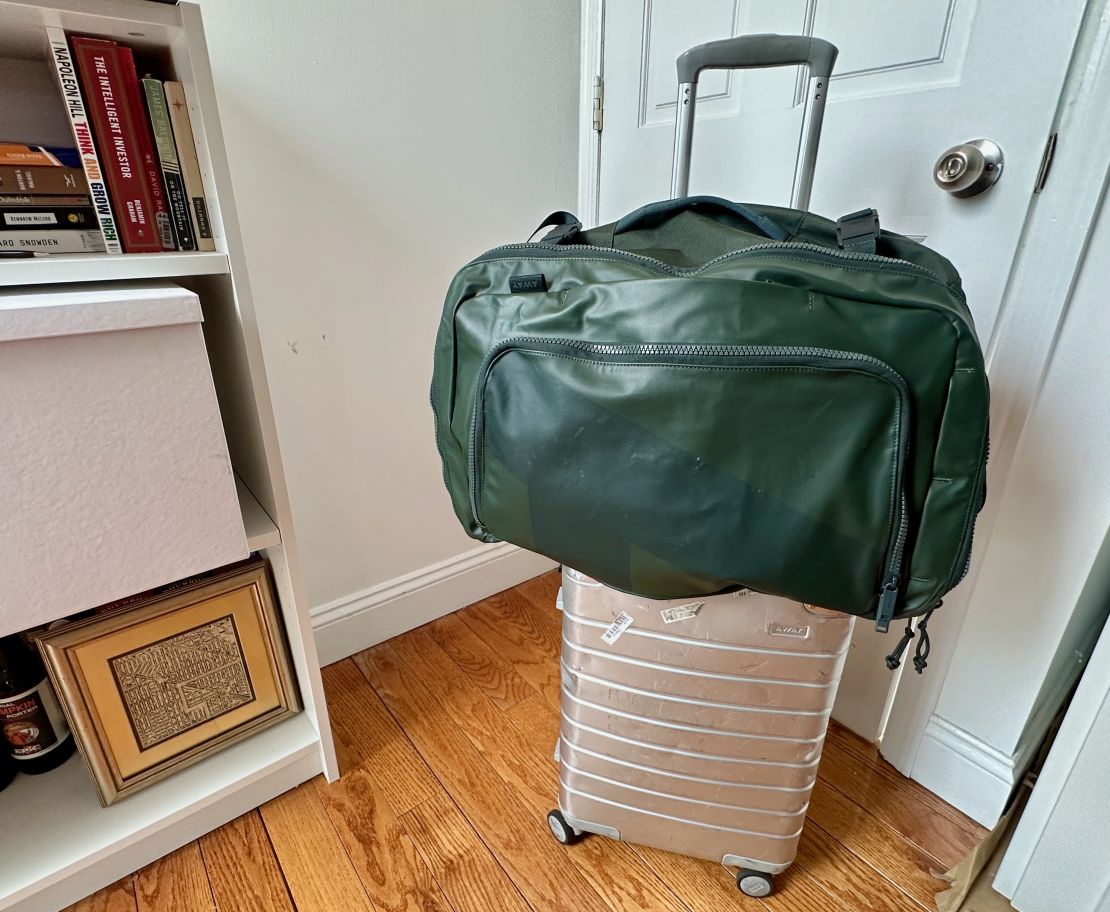 A photo of the Away FAR 45L backpack attached to an Away aluminum carry on bag