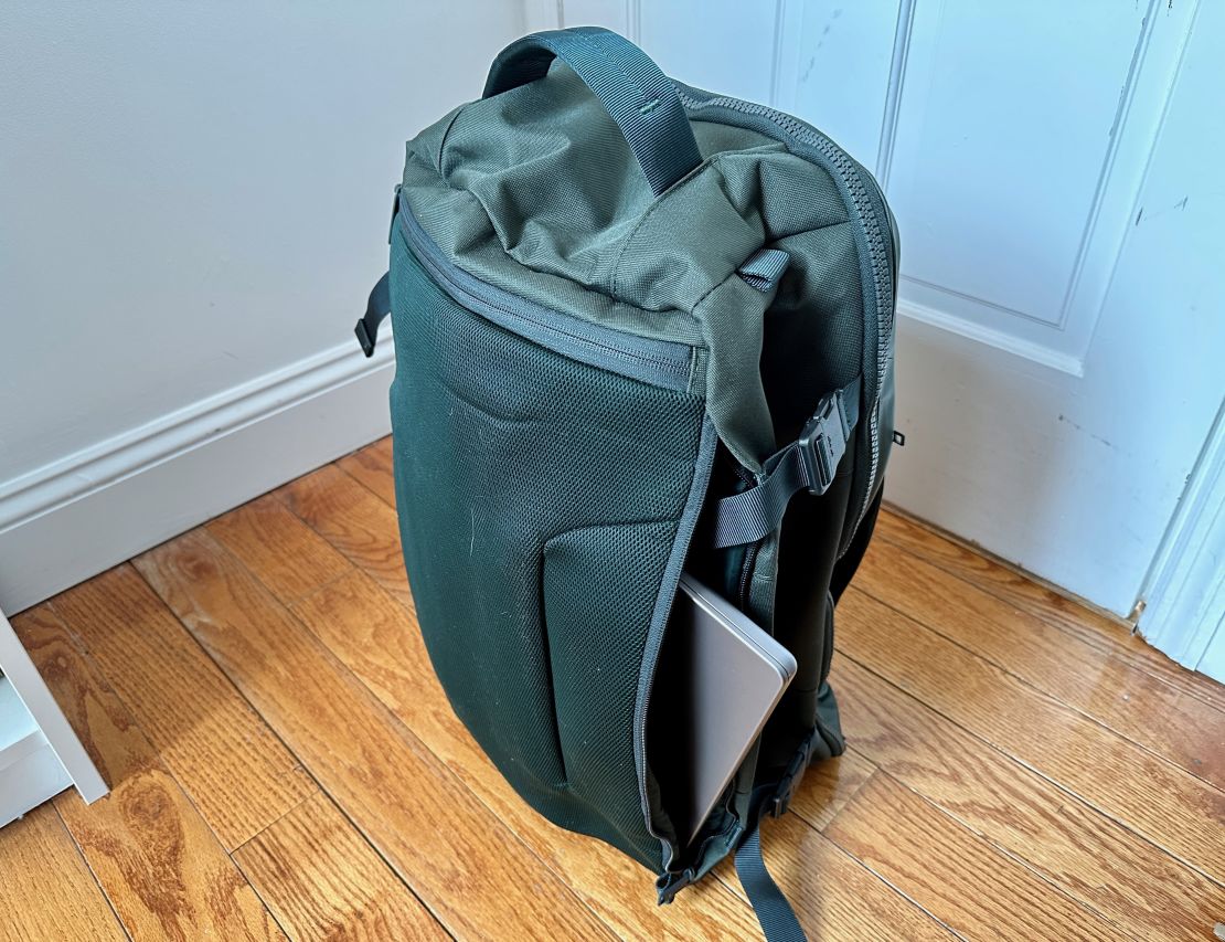 The Away FAR 45L convertible backpack with a laptop sticking out of the back pocket