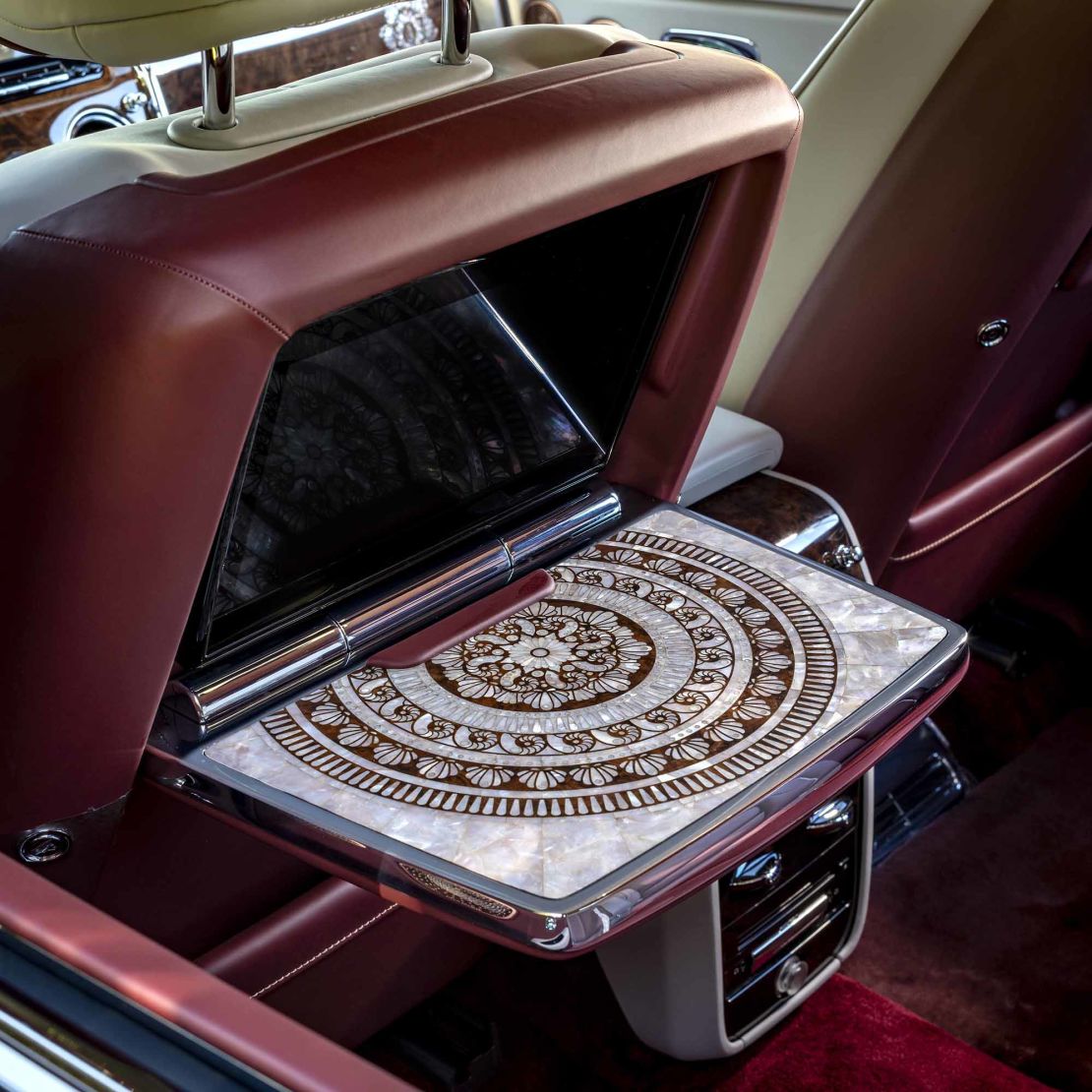 Mother-of-pearl inlay on a folding tray table inside a customized Rolls-Royce Cullinan SUV.