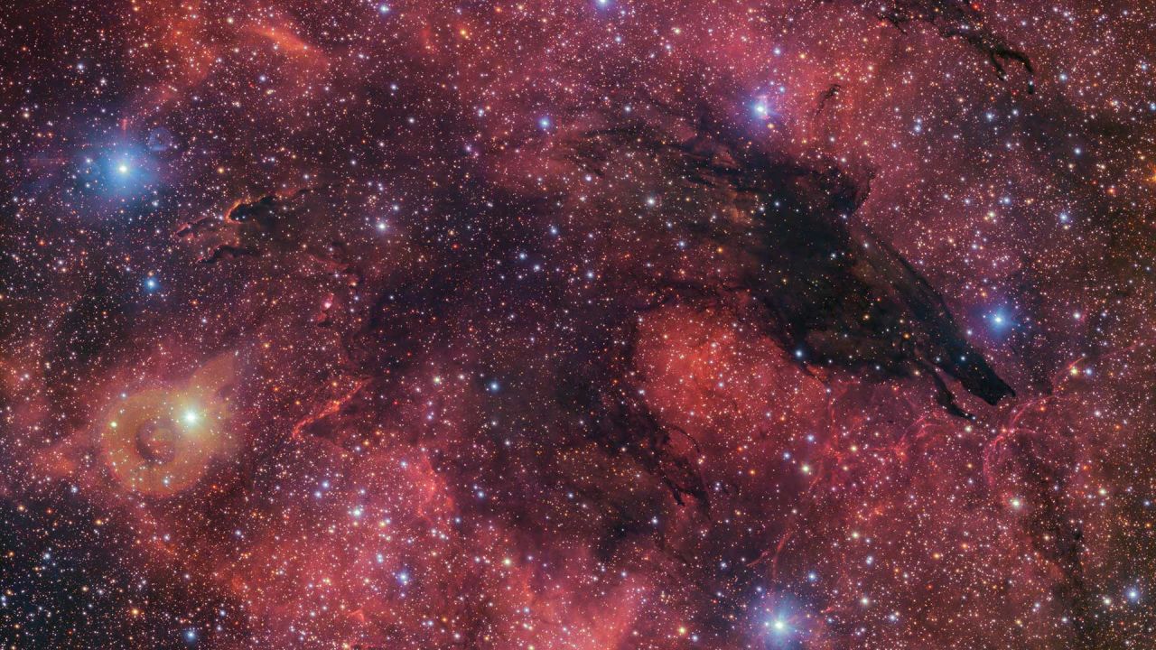 Fittingly nicknamed the Dark Wolf Nebula, this cosmic cloud was captured in a 283-million-pixel image by the VLT Survey Telescope (VST) at ESO’s Paranal Observatory in Chile. Located around 5300 light-years from Earth, the cold clouds of cosmic dust create the illusion of a wolf-like silhouette against a colourful backdrop of glowing gas clouds.