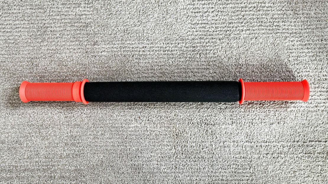 A Tiger Tail 18-Inch Massage Stick on a carpet surface.