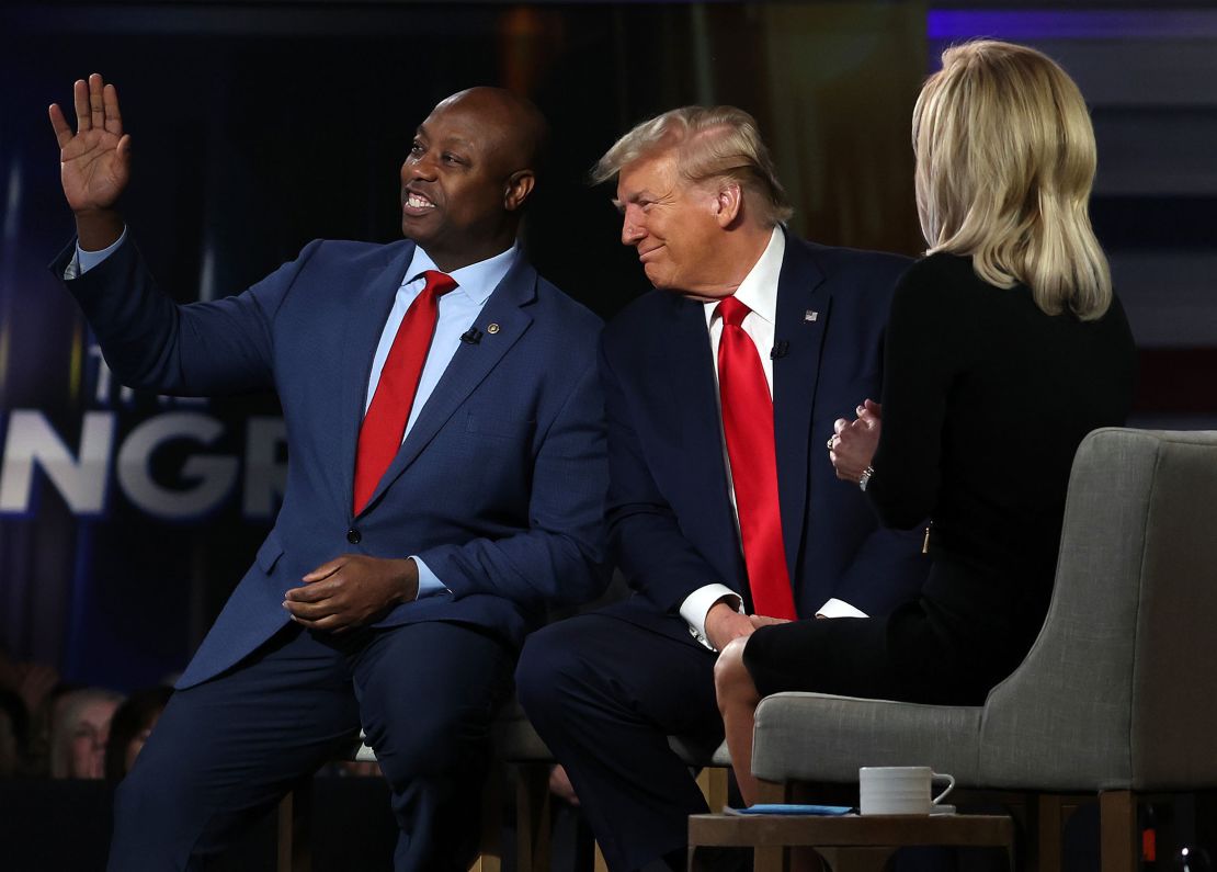 Sen. Tim Scott waves as he sits with former President Donald Trump during a Fox News town hall at the Greenville Convention Center on February 20, 2024 in Greenville, South Carolina. 