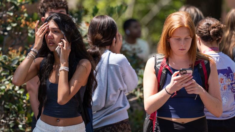 Personas son escoltadas fuera de los edificios tras disparos en el campus de la Universidad Estatal de Florida el jueves.