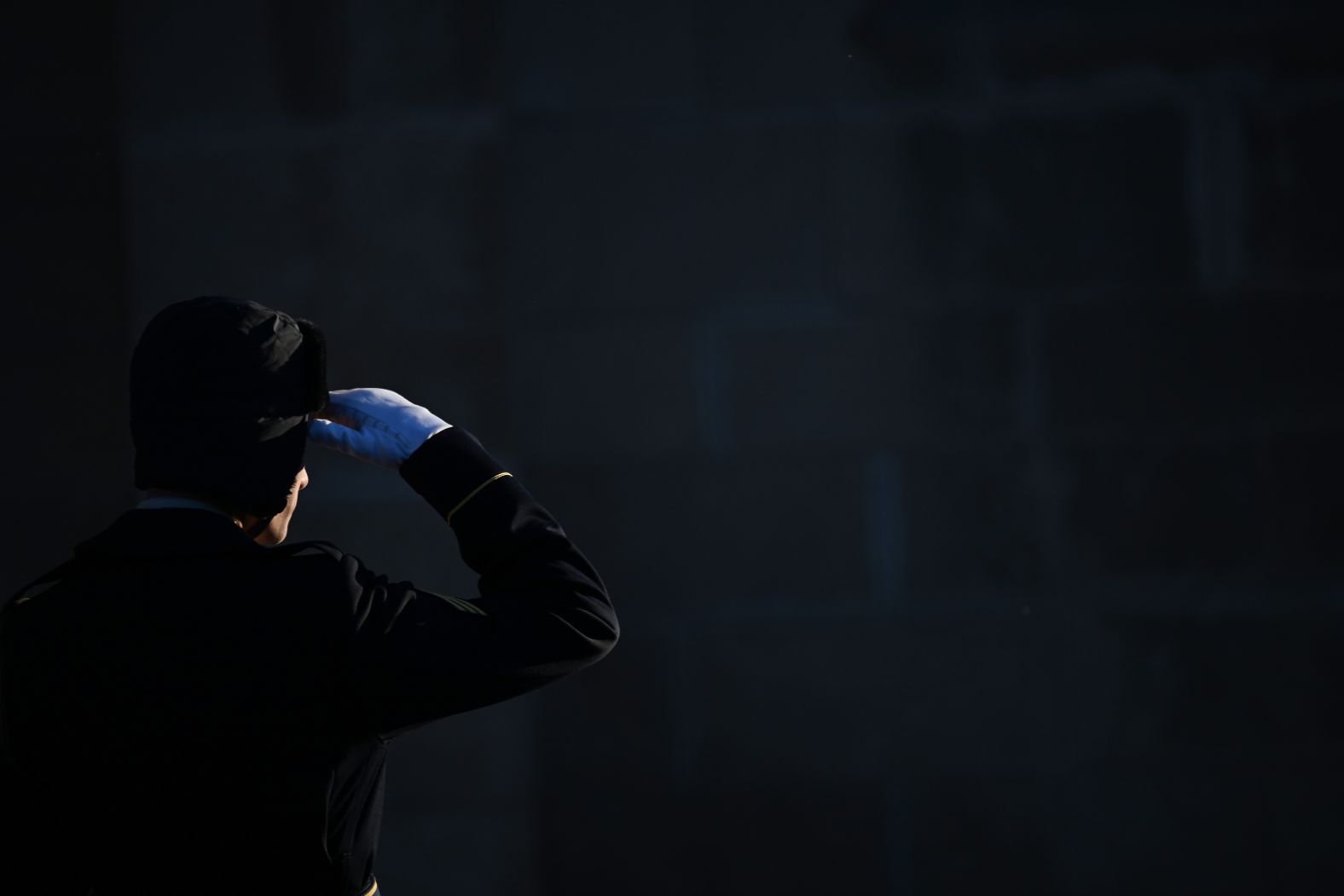 A military member salutes before the funeral.