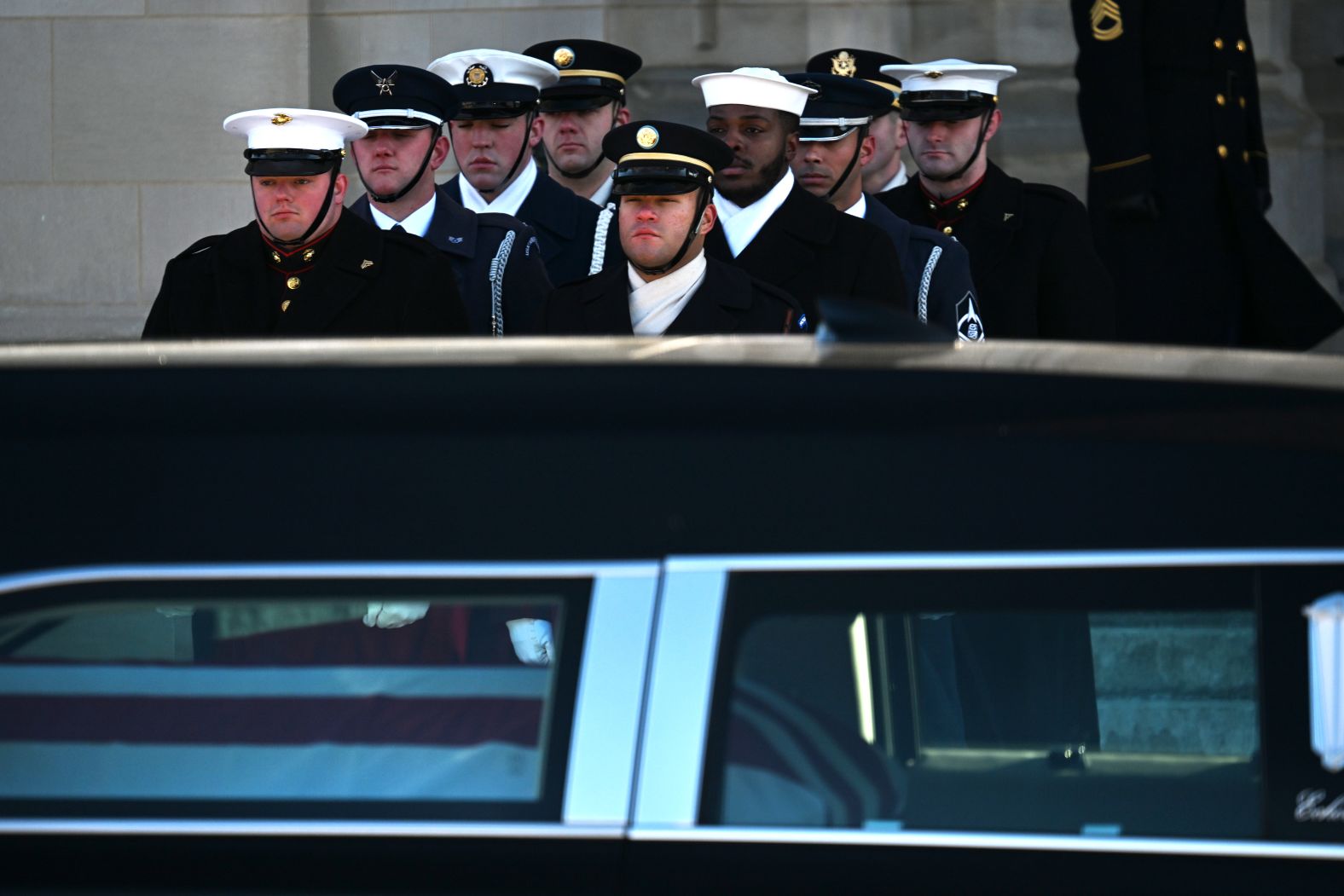 Military members wait to receive Carter's casket outside of the cathedral.