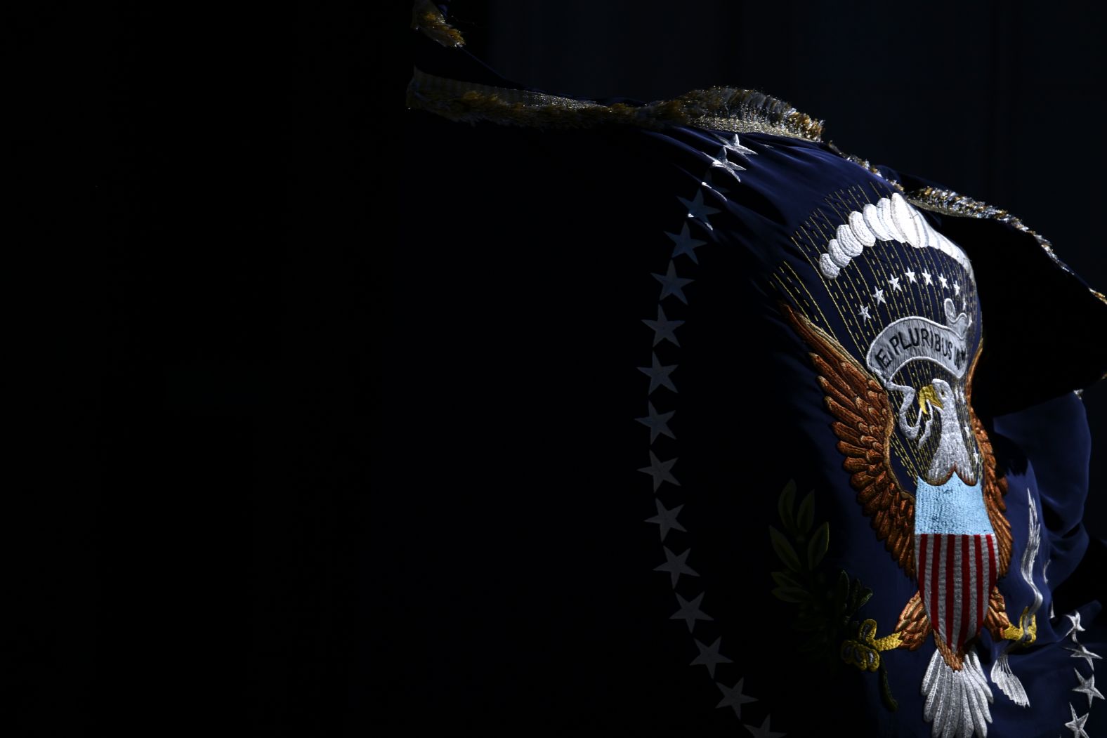 A flag with the presidential seal is carried at the funeral.