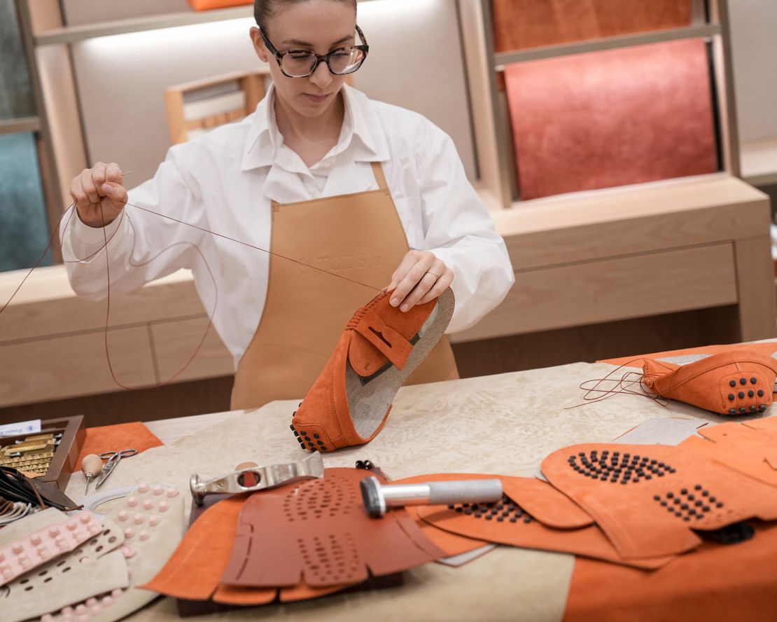 Tod's often puts its artisans front and center: In its store, a craftsperson shows how part of the brand's signature Gommino loafer is made.
