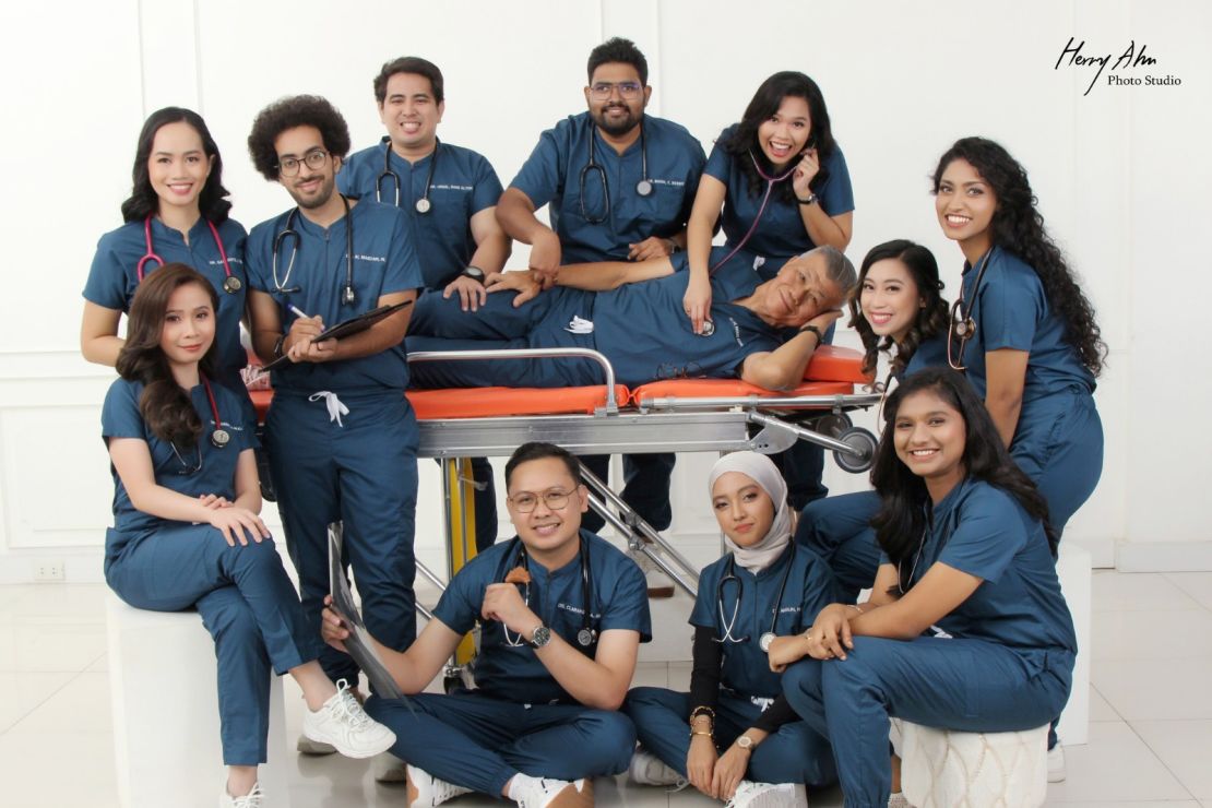 Posing on a stretcher, Toh and his cohort completed medical school together.