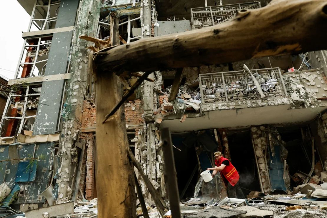 Un trabajador municipal limpia un edificio de apartamentos en Kyiv que fue dañado por un ataque con drones ruso el domingo.
