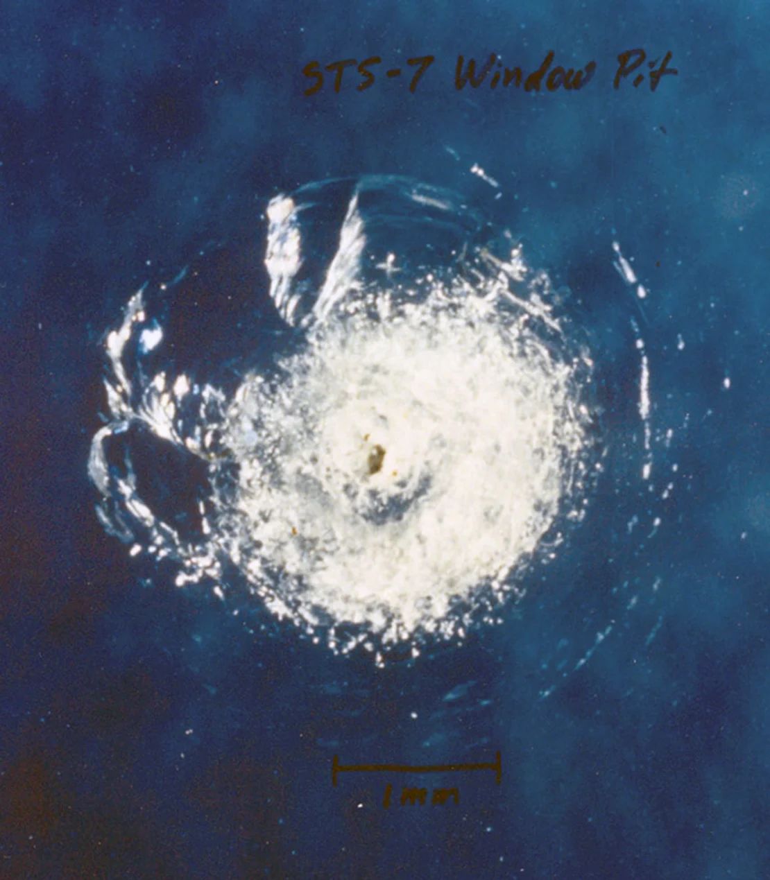 Un hoyo en la ventana del transbordador espacial Challenger fue el resultado del impacto de un residuo orbital causado por una astilla de pintura durante la misión STS-7 en 1983.