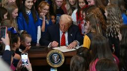 El presidente Donald Trump, junto a atletas femeninas, firma un decreto contra la participación de personas trans en deportes.