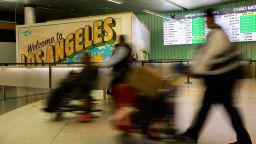 Los viajeros empujan su equipaje a través del área de llegadas internacionales del Aeropuerto Internacional de Los Ángeles el sábado.