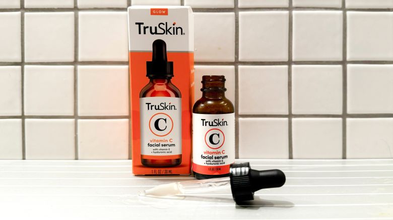 A container of TruSkin Vitamin C Serum with its dropper on a bathroom counter.