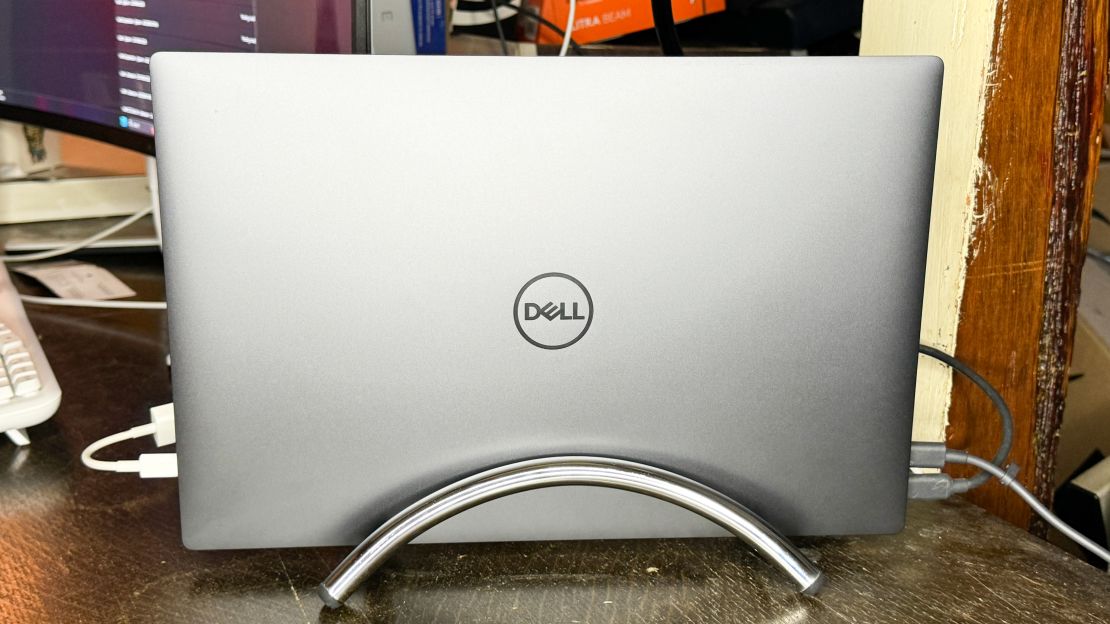 A Dell XPS laptop stands upright in the chrome Twelve South BookArc Flex at a desk.