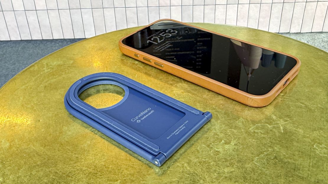 The folded-up Twelve South Curve Nano is smaller than the iPhone it's next to on a table