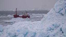 A ship cuts through the icy waters off the southeast Greenland coast.