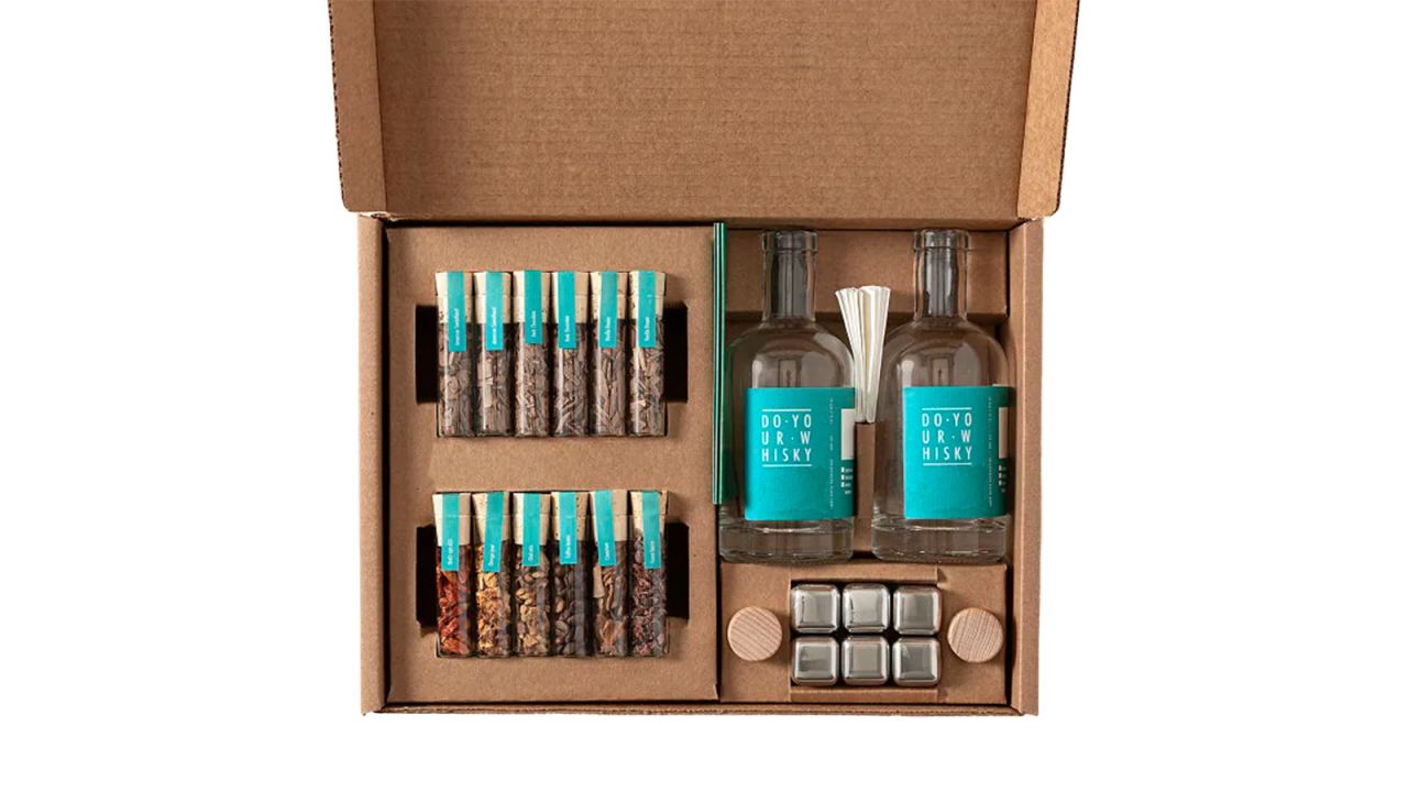 The boxed contents of the Uncommon Goods Whiskey Making Kit on a white background.