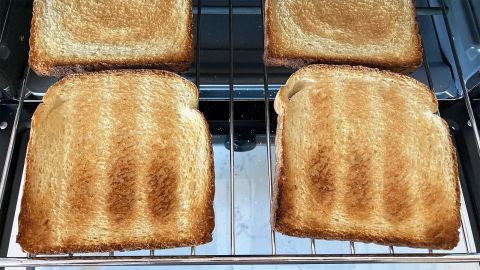 An open toaster oven, showing four slices of toast