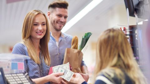 Couple using cash to buy in store