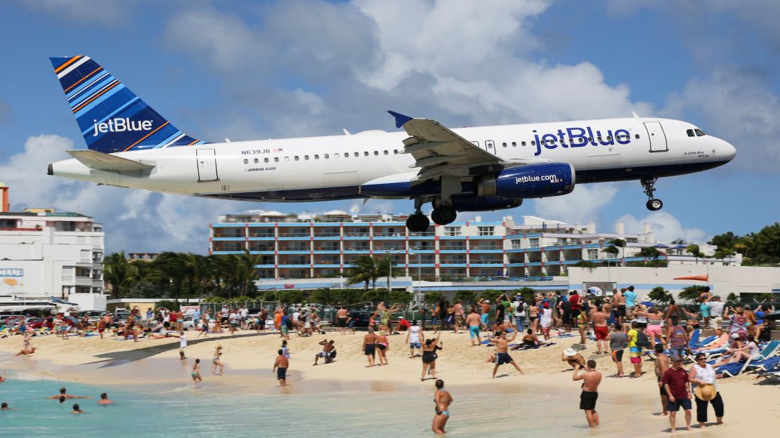 underscored jetblue plane flying over beach