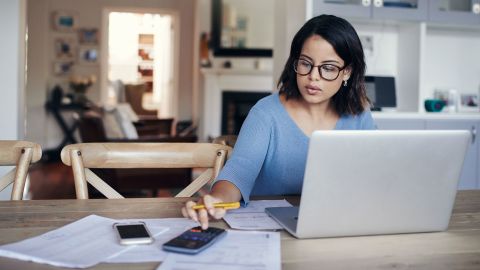Woman with calculator and laptop budget getting out of debt