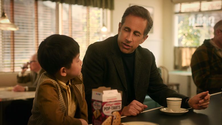(L to R) Isaac Bae as George and Jerry Seinfeld (Director) as Bob Cabana in Unfrosted.